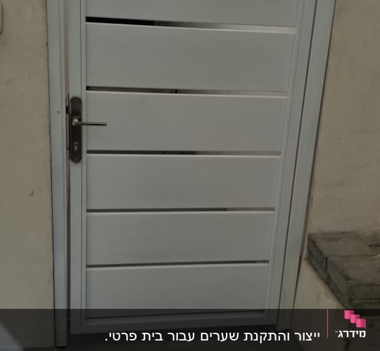 שער מתכת לבן עם ידית בצד חיצוני